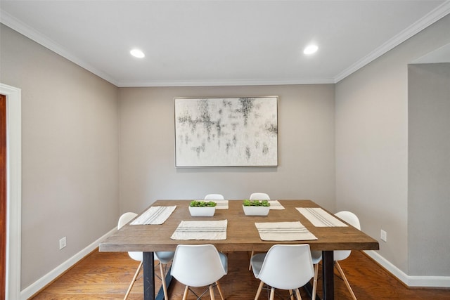 dining area featuring crown molding, baseboards, and wood finished floors