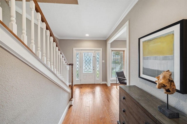 entryway featuring ornamental molding, stairs, baseboards, recessed lighting, and light wood finished floors