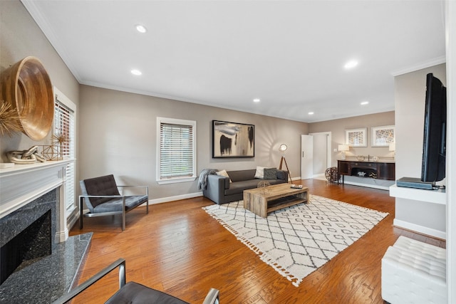 living room featuring crown molding, recessed lighting, baseboards, wood finished floors, and a high end fireplace