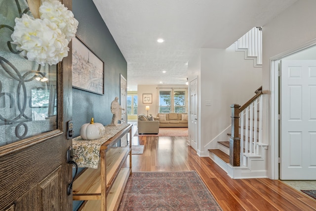 entrance foyer with recessed lighting, baseboards, wood finished floors, and stairway