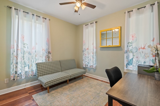 home office with baseboards, ceiling fan, and wood finished floors
