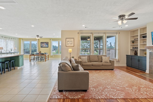 living room with a ceiling fan, recessed lighting, and a textured ceiling