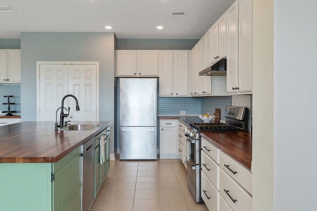 kitchen with a sink, appliances with stainless steel finishes, wooden counters, and visible vents
