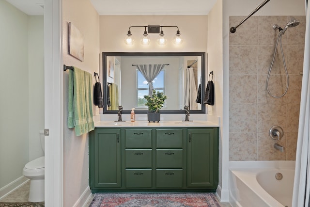bathroom featuring double vanity, a sink, shower / bath combination, and toilet