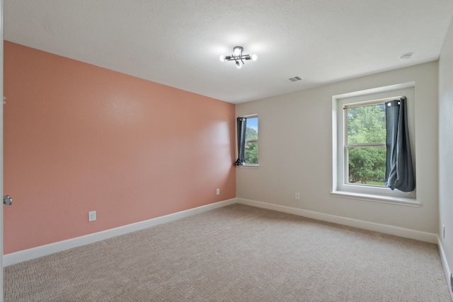 spare room featuring baseboards and light colored carpet