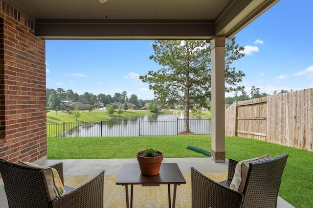 view of patio / terrace featuring a water view and a fenced backyard