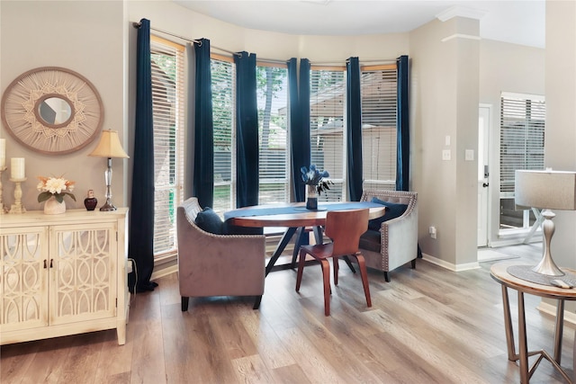 dining space featuring light wood-style flooring and baseboards