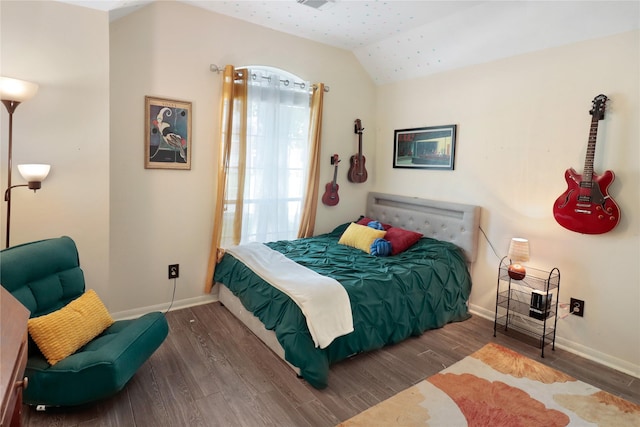 bedroom with lofted ceiling, wood finished floors, and baseboards