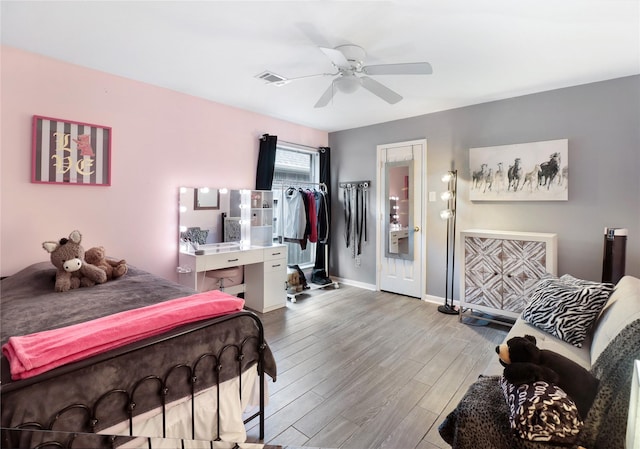 bedroom with baseboards, visible vents, wood finished floors, and ceiling fan