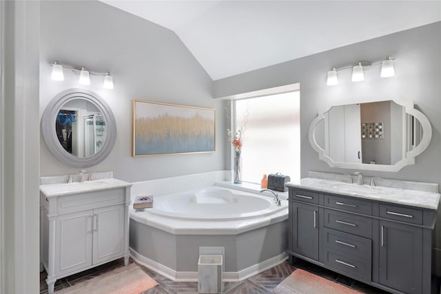 bathroom with two vanities, lofted ceiling, and a sink