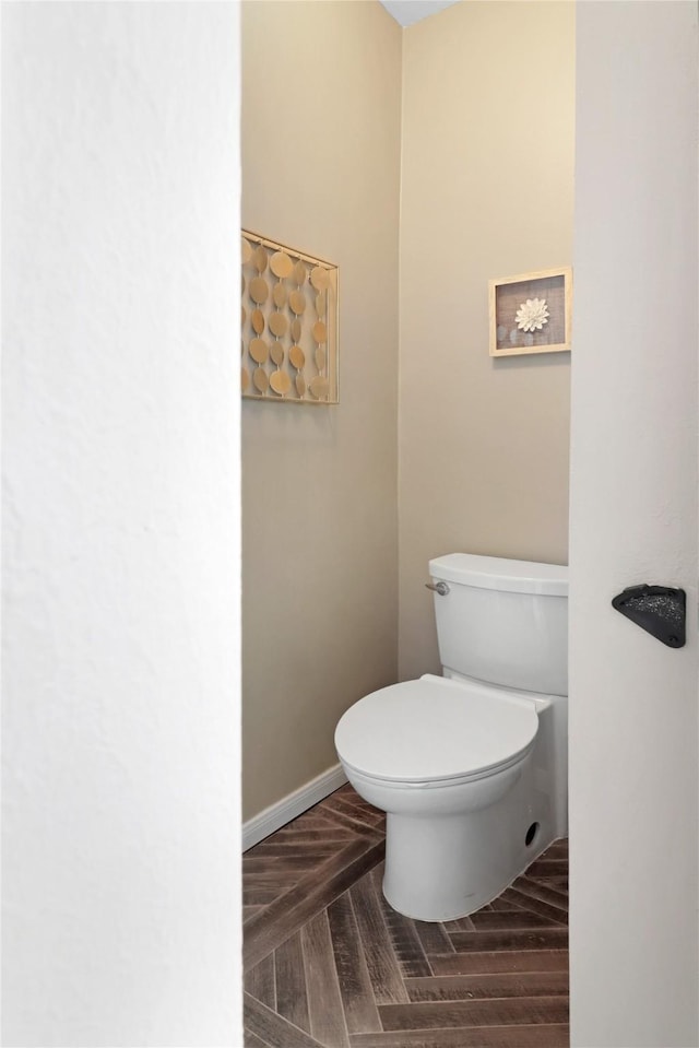 bathroom featuring toilet and baseboards