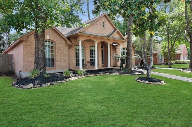 view of front of property featuring fence, a front yard, and brick siding