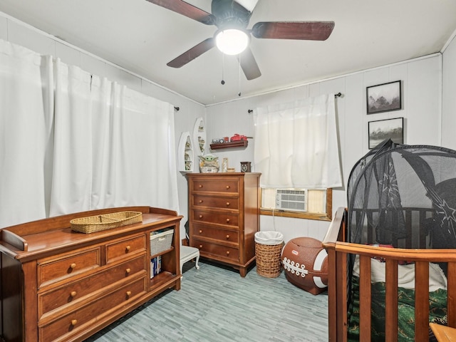 bedroom with wood finished floors, cooling unit, and ceiling fan