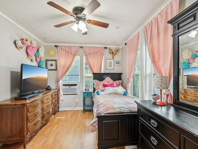bedroom featuring light wood-type flooring, cooling unit, a ceiling fan, and baseboards