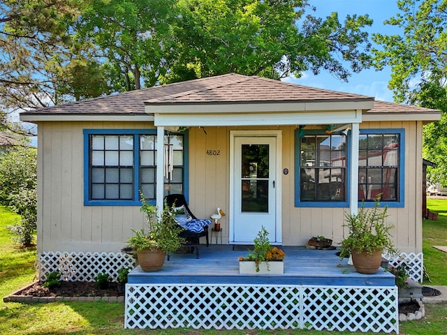 view of front of house featuring a shingled roof and a front lawn