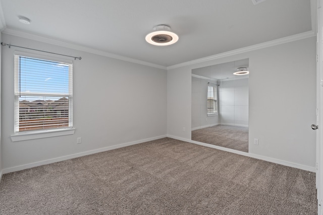 carpeted spare room with crown molding and baseboards