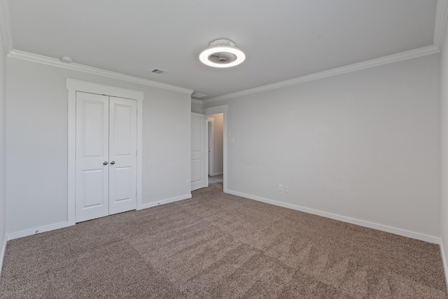 unfurnished bedroom featuring crown molding, visible vents, a closet, baseboards, and carpet flooring