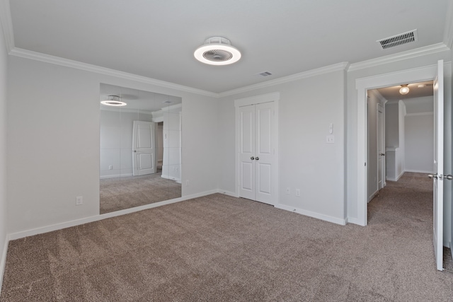 unfurnished bedroom with crown molding, baseboards, visible vents, and carpet