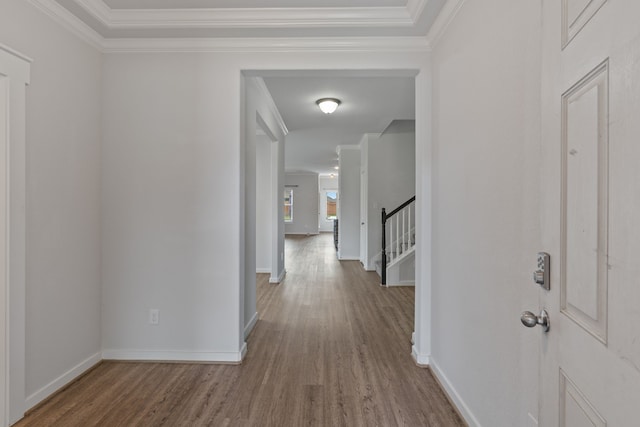 hallway with crown molding, baseboards, and wood finished floors
