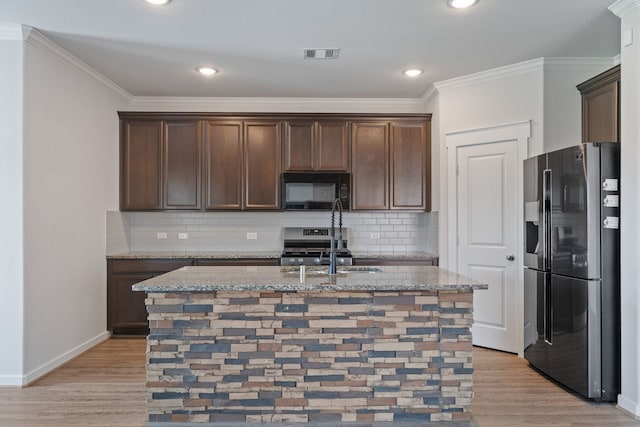 kitchen featuring visible vents, appliances with stainless steel finishes, light wood finished floors, and dark brown cabinets