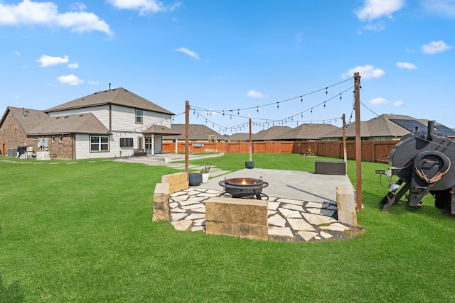 view of yard featuring a fenced backyard, a fire pit, and a patio area