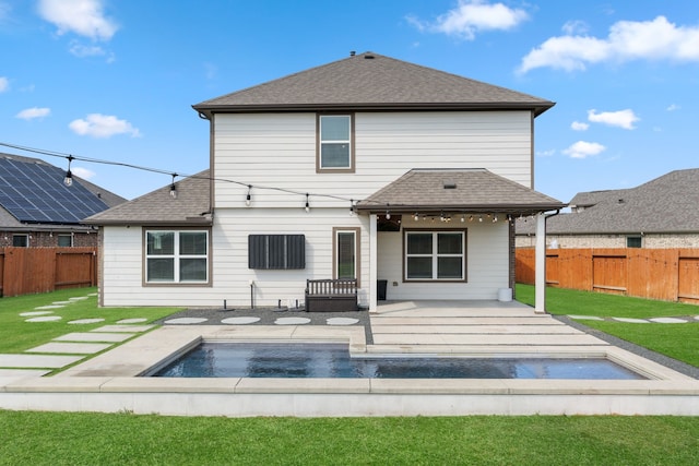 rear view of house featuring a lawn, a fenced backyard, a fenced in pool, and a shingled roof