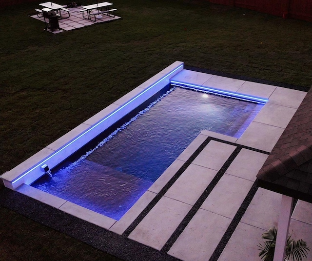 view of pool with a lawn