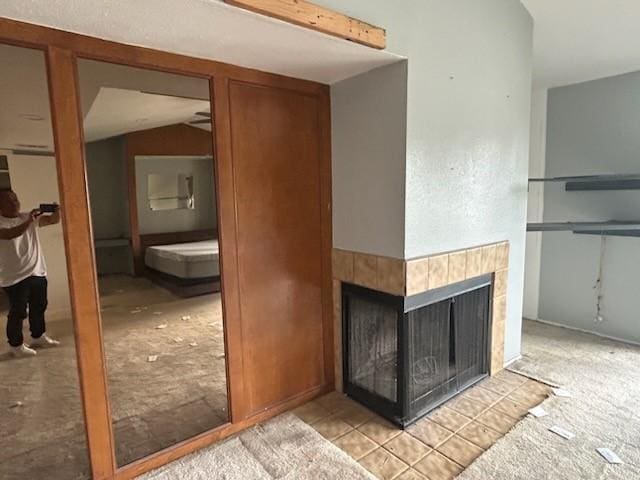 details with a tile fireplace and carpet