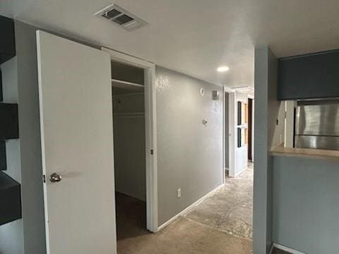 hall featuring visible vents, carpet, and baseboards