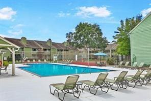 community pool with fence and a patio area