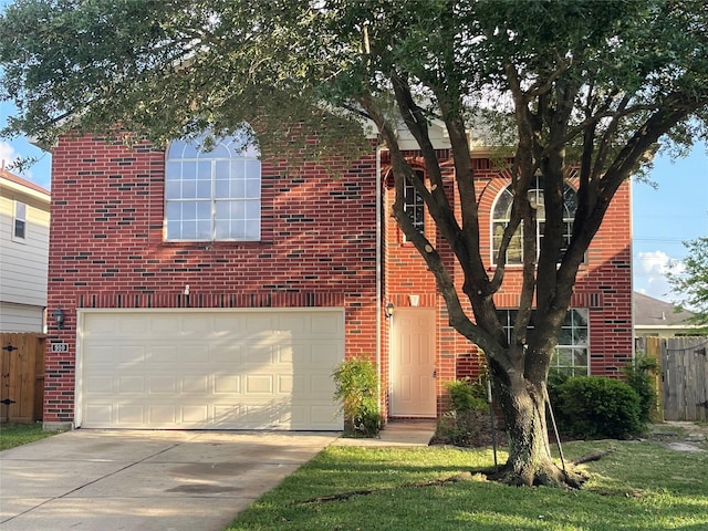 traditional-style home featuring fence, an attached garage, concrete driveway, and brick siding