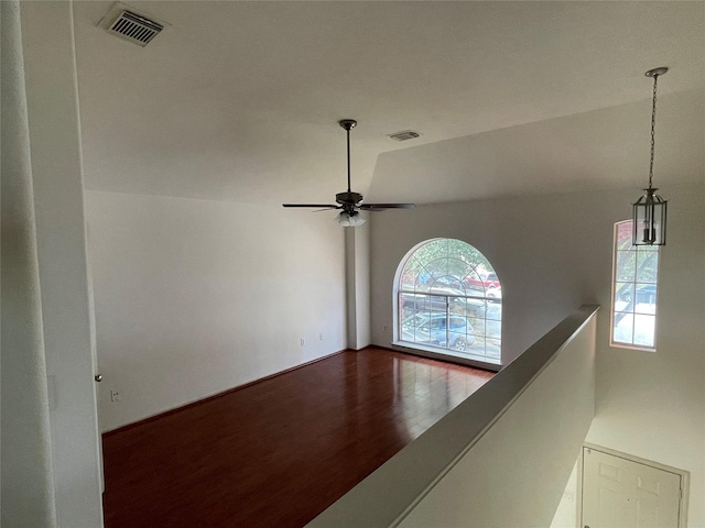 interior space featuring a ceiling fan, visible vents, and wood finished floors
