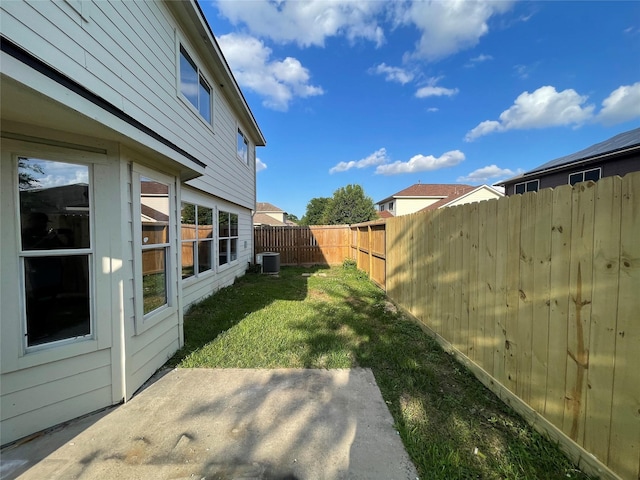 view of yard with a fenced backyard, a patio, and central air condition unit
