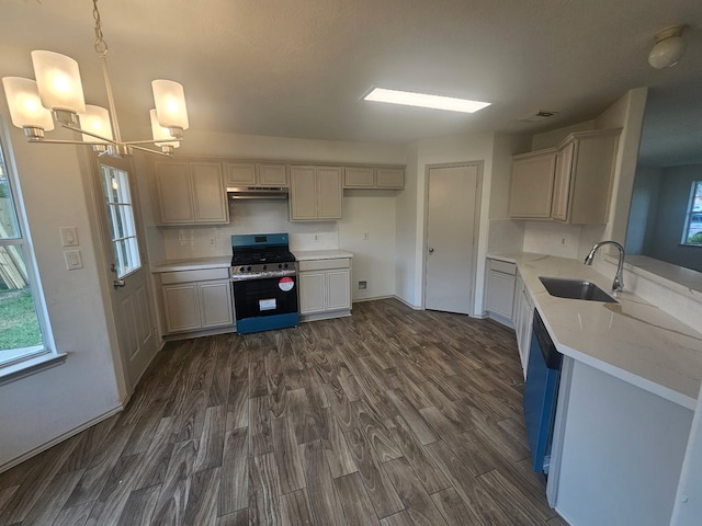 kitchen featuring dark wood-style flooring, an inviting chandelier, a sink, gas stove, and light countertops