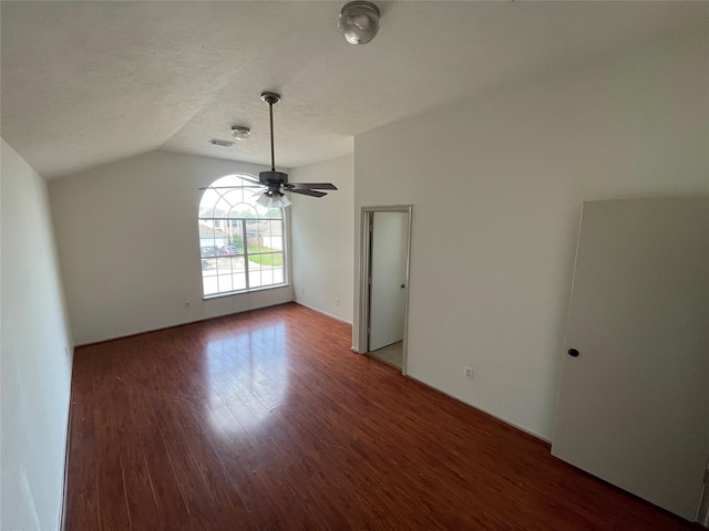 empty room featuring ceiling fan, a textured ceiling, visible vents, wood finished floors, and lofted ceiling