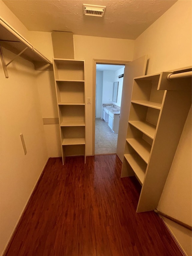 spacious closet featuring dark wood-style floors and visible vents