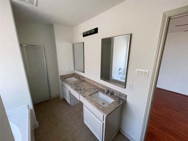 full bath featuring a sink, tile patterned floors, double vanity, and visible vents