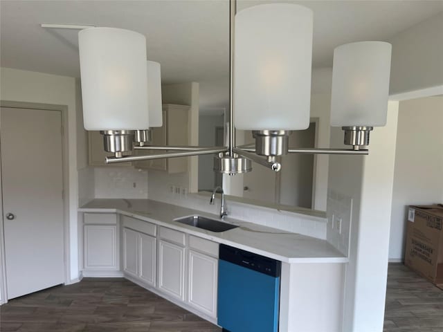 kitchen featuring dark wood-type flooring, light countertops, tasteful backsplash, a sink, and dishwasher