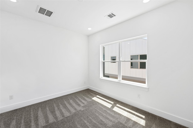 carpeted empty room featuring baseboards, visible vents, and recessed lighting