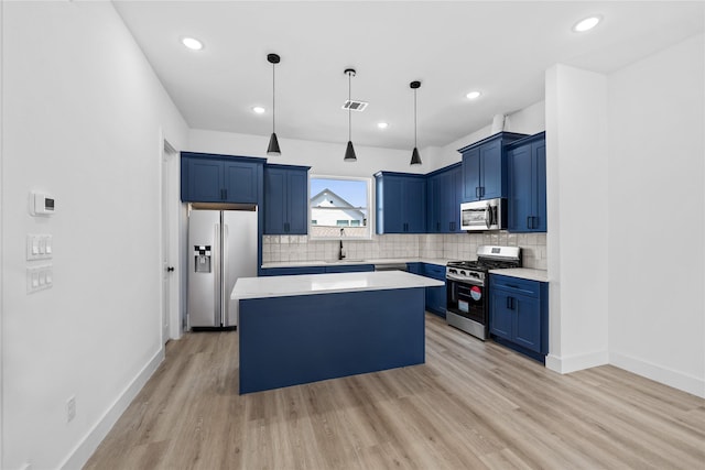 kitchen with stainless steel appliances, blue cabinetry, a center island, visible vents, and light countertops