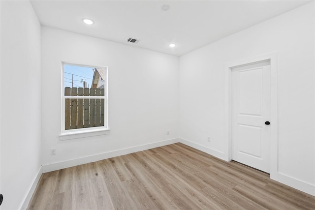 empty room featuring recessed lighting, visible vents, light wood-style flooring, and baseboards