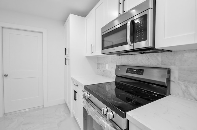 6107 Kuldell Dr, Houston, TX 77074 - kitchen with stainless steel appliances, light marble finish flooring, light stone countertops, white cabinetry, and backsplash