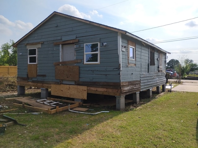 rear view of property with a lawn and fence