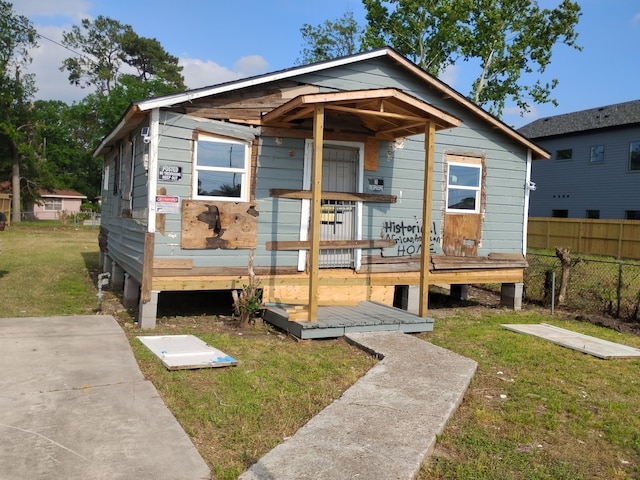 bungalow with fence and a front lawn