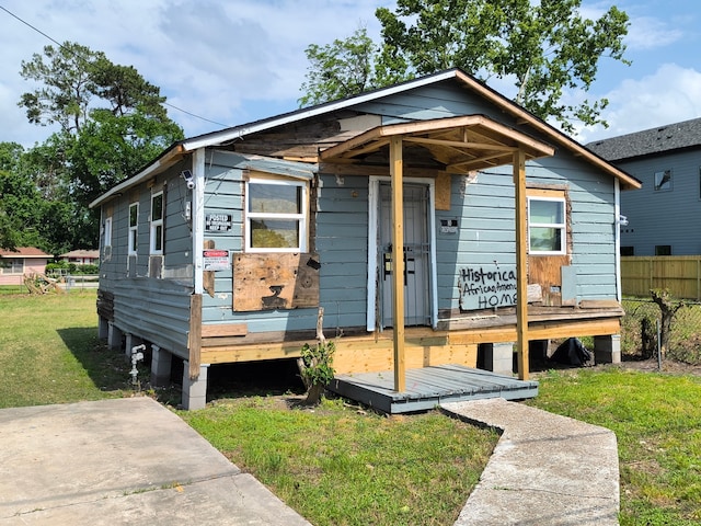 bungalow with fence and a front yard