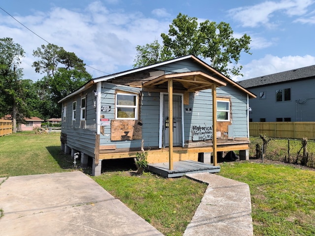 bungalow with fence, a patio area, and a front yard
