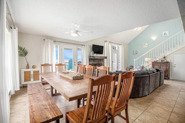 dining area featuring stairway, a healthy amount of sunlight, ceiling fan, and a textured ceiling
