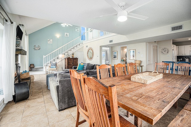 dining room with visible vents, light tile patterned floors, ceiling fan, and stairs