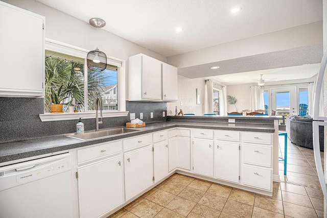 kitchen with a sink, dark countertops, dishwasher, and plenty of natural light