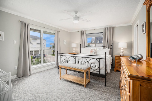 carpeted bedroom with crown molding, a ceiling fan, and baseboards